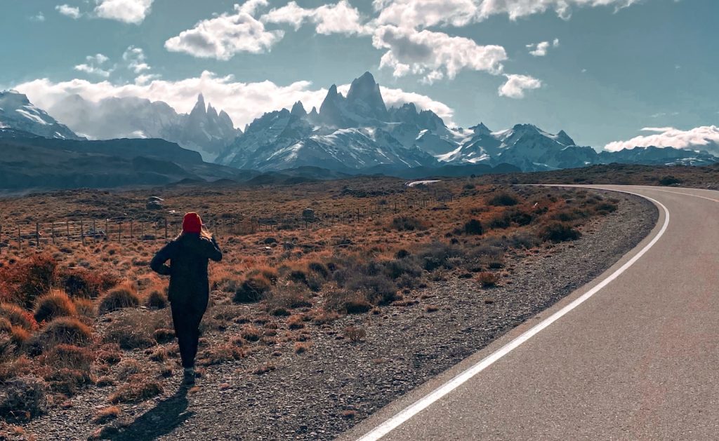 a person running down a road with mountains in the background